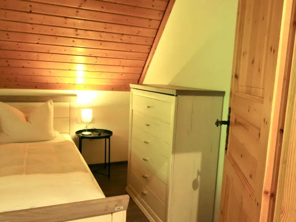 Ferienwohnung Bergseite: Schlafzimmer mit Kommode und Holzverkleidung