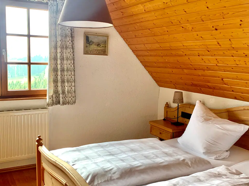 Ferienwohnung Talseite: Bett unter der holzverkleideten Dachschräge